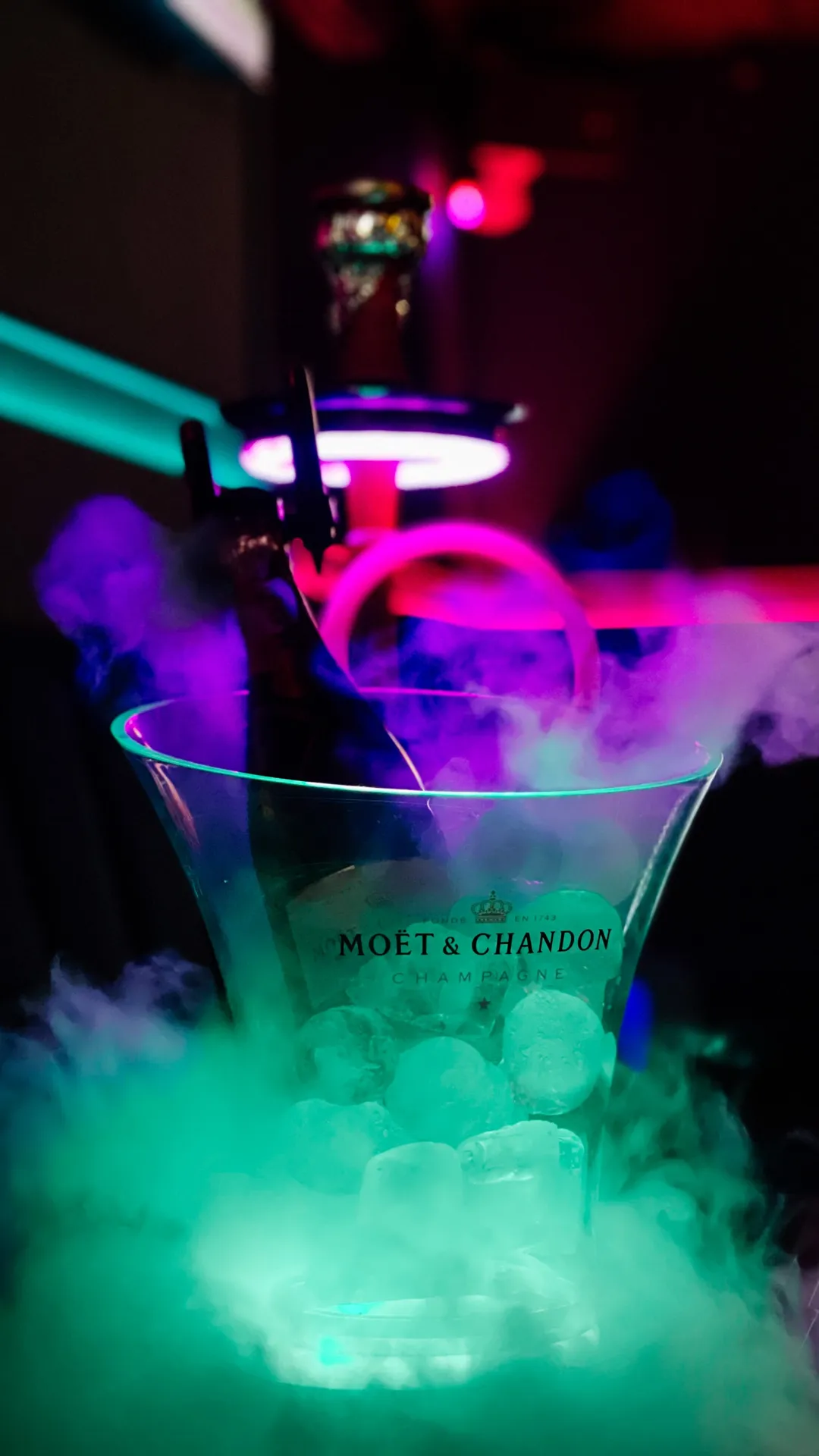 Botella de champán en cubitera con hielo y cachimba en una mesa de Maguana Club